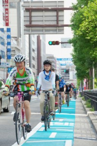 （写真）本町通の自転車レーンを走るアピール走行参加者たち