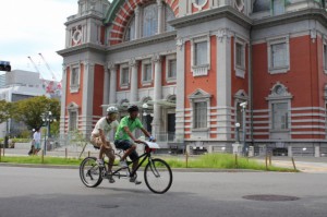 （写真）中央公会堂の前を走るタンデム自転車