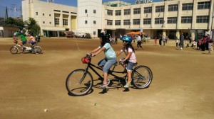 （写真）女の子が２人でタンデム自転車に乗っています