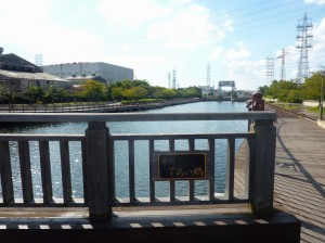 （写真）「であい橋」と書かれたプレートが橋の欄干についています。下には運河が流れています