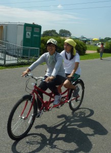 （写真）タンデム自転車に２人が乗って走っているところ