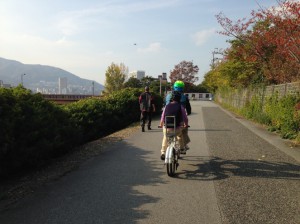 （写真）武庫川河川敷をタンデム自転車が走っているところ
